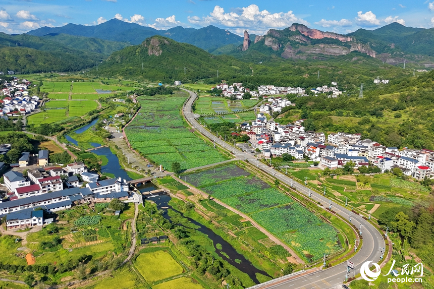 蜿蜒的柏油公路犹如银龙穿行翠绿山间，与村庄、农田、山峦、河流相映成趣，构成一幅路畅通、景色美的夏日乡村画卷。人民网记者 朱海鹏摄