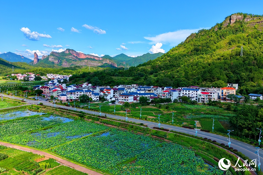 蜿蜒的柏油公路犹如银龙穿行翠绿山间，与村庄、农田、山峦、河流相映成趣，构成一幅路畅通、景色美的夏日乡村画卷。人民网记者 朱海鹏摄