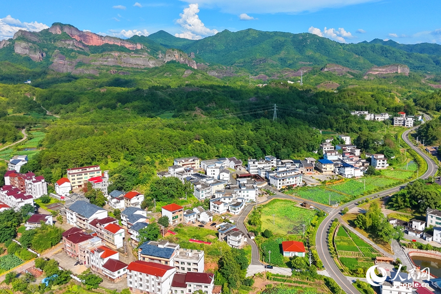 蜿蜒的柏油公路犹如银龙穿行翠绿山间，与村庄、农田、山峦、河流相映成趣，构成一幅路畅通、景色美的夏日乡村画卷。人民网记者 朱海鹏摄