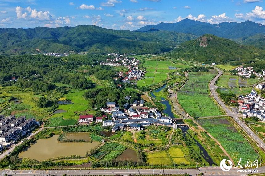 蜿蜒的柏油公路犹如银龙穿行翠绿山间，与村庄、农田、山峦、河流相映成趣，构成一幅路畅通、景色美的夏日乡村画卷。人民网记者 朱海鹏摄
