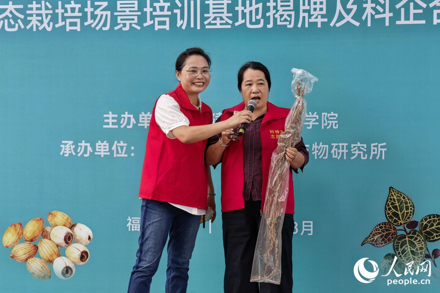 苏海兰（左）引导傅梅桃介绍农产品。人民网记者 林盈摄